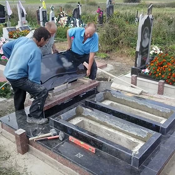 Процесс установки гранитного памятника на кладбище